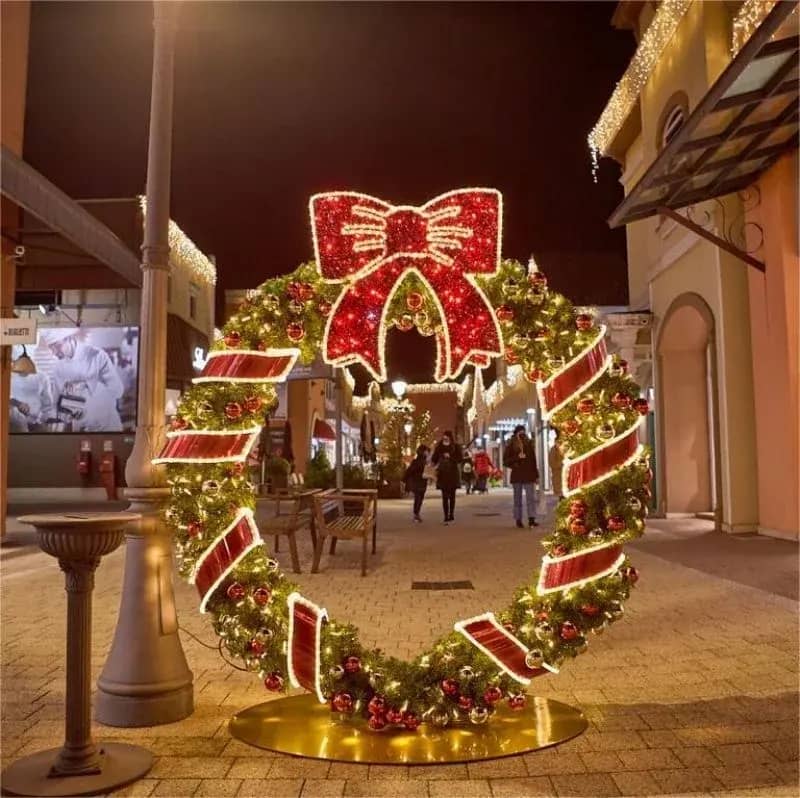 Large lit commercial Christmas wreath with a red bow