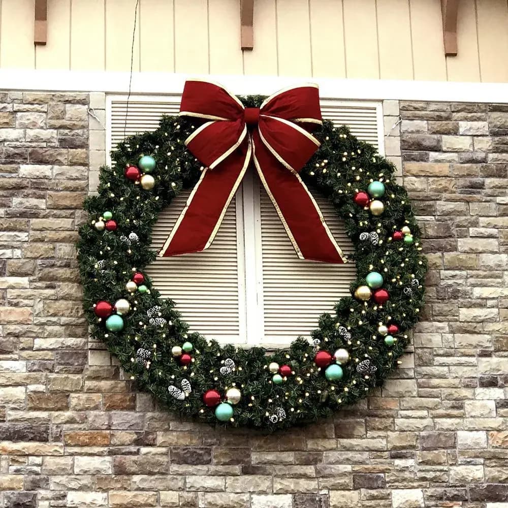 Decorated commercial wreath mounted on a stone building facade