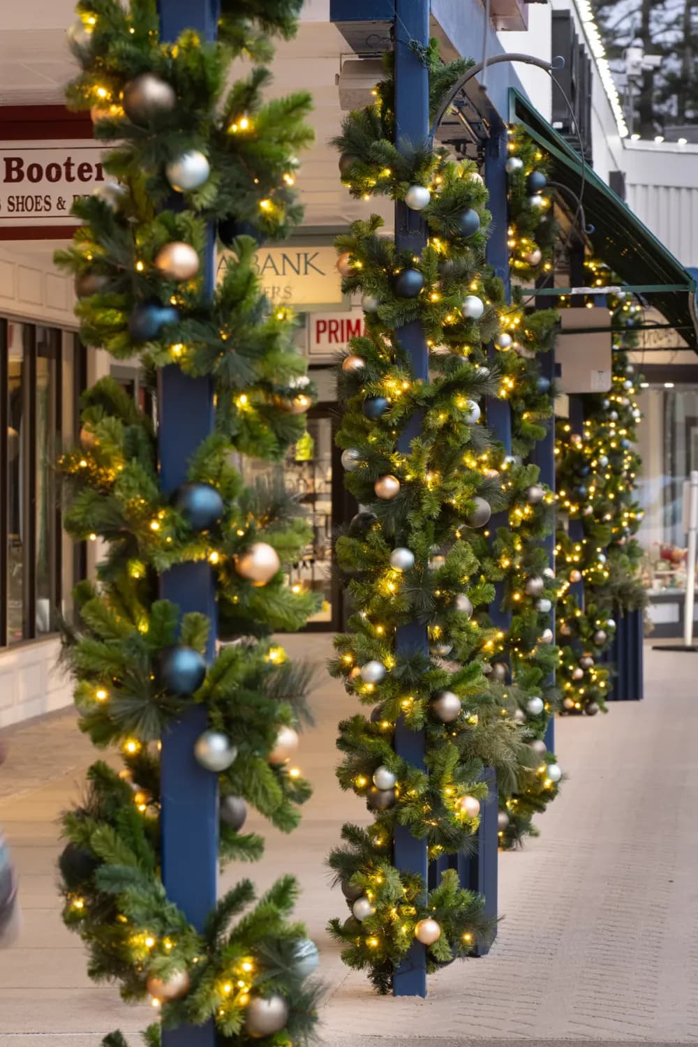 Lit garland pole wrap and street-light décor on a downtown street