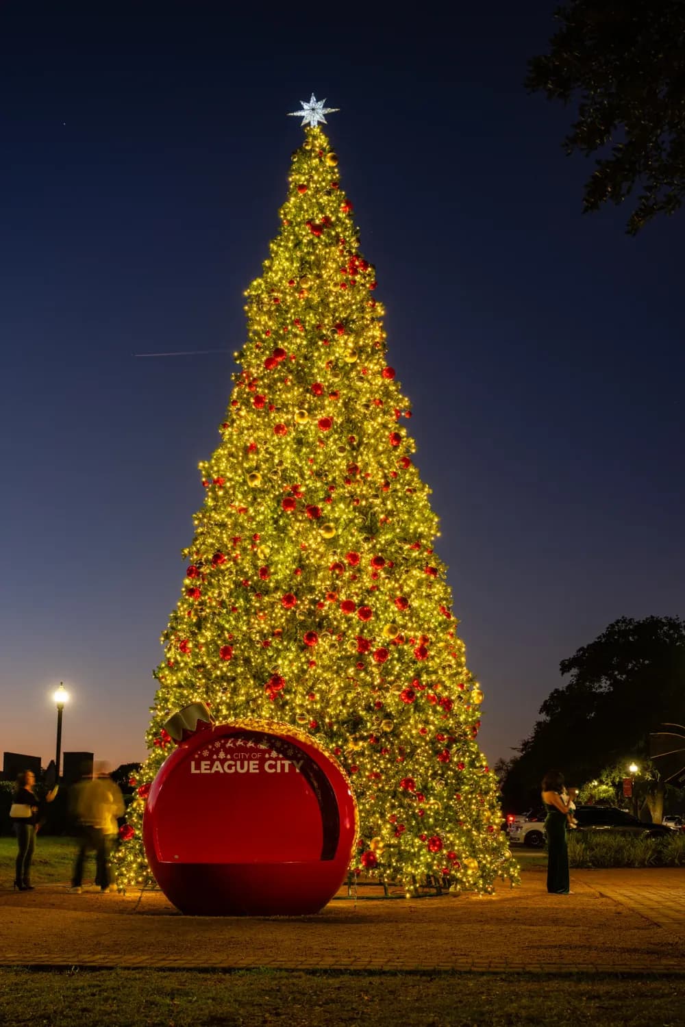 Commercial Christmas tree installed and lit on a retail plaza at night